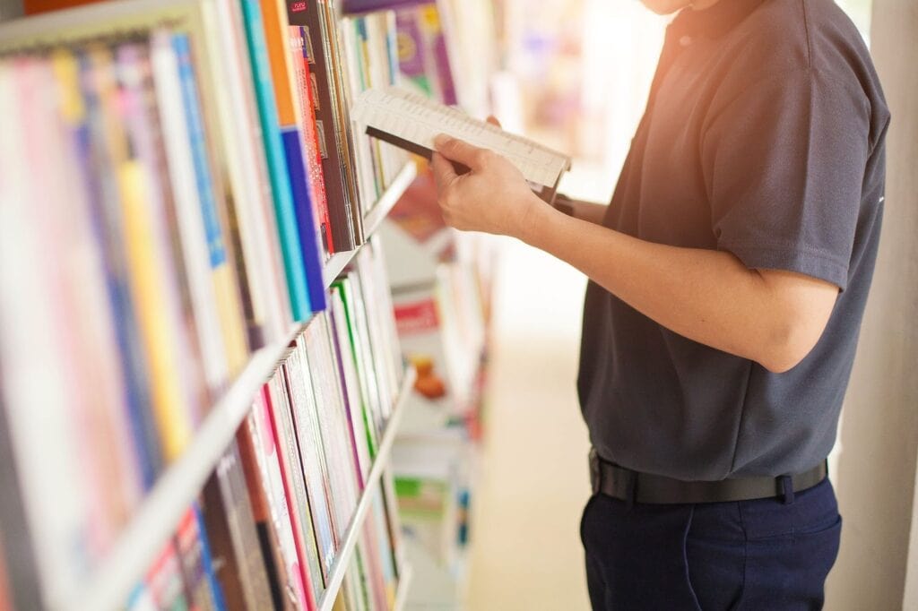 Man in bookstore reading book