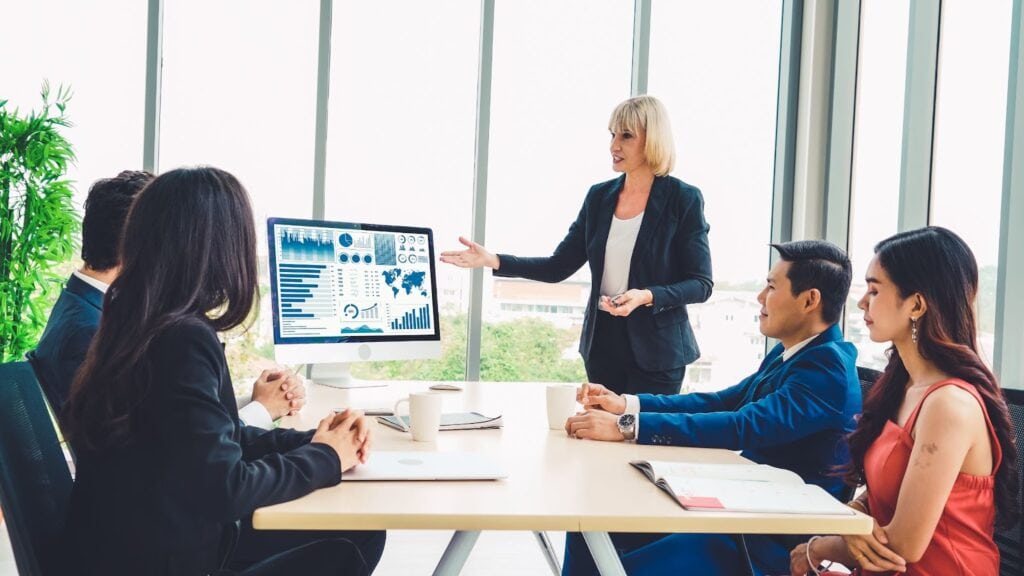 Group of people meeting with woman presenting analytics