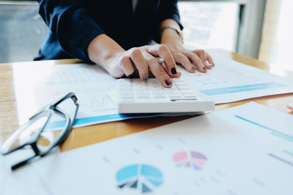 Business woman using calculator and laptop