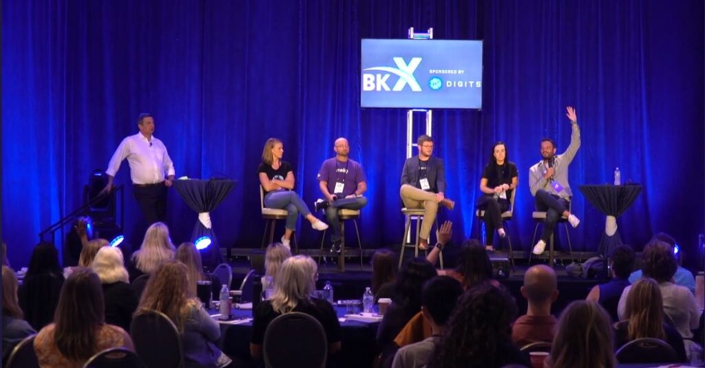 Attendees watch a discussion at an accounting conference.